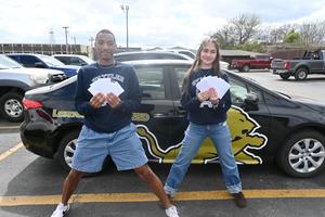 Two seniors showing the gift cards donated for project graduation.