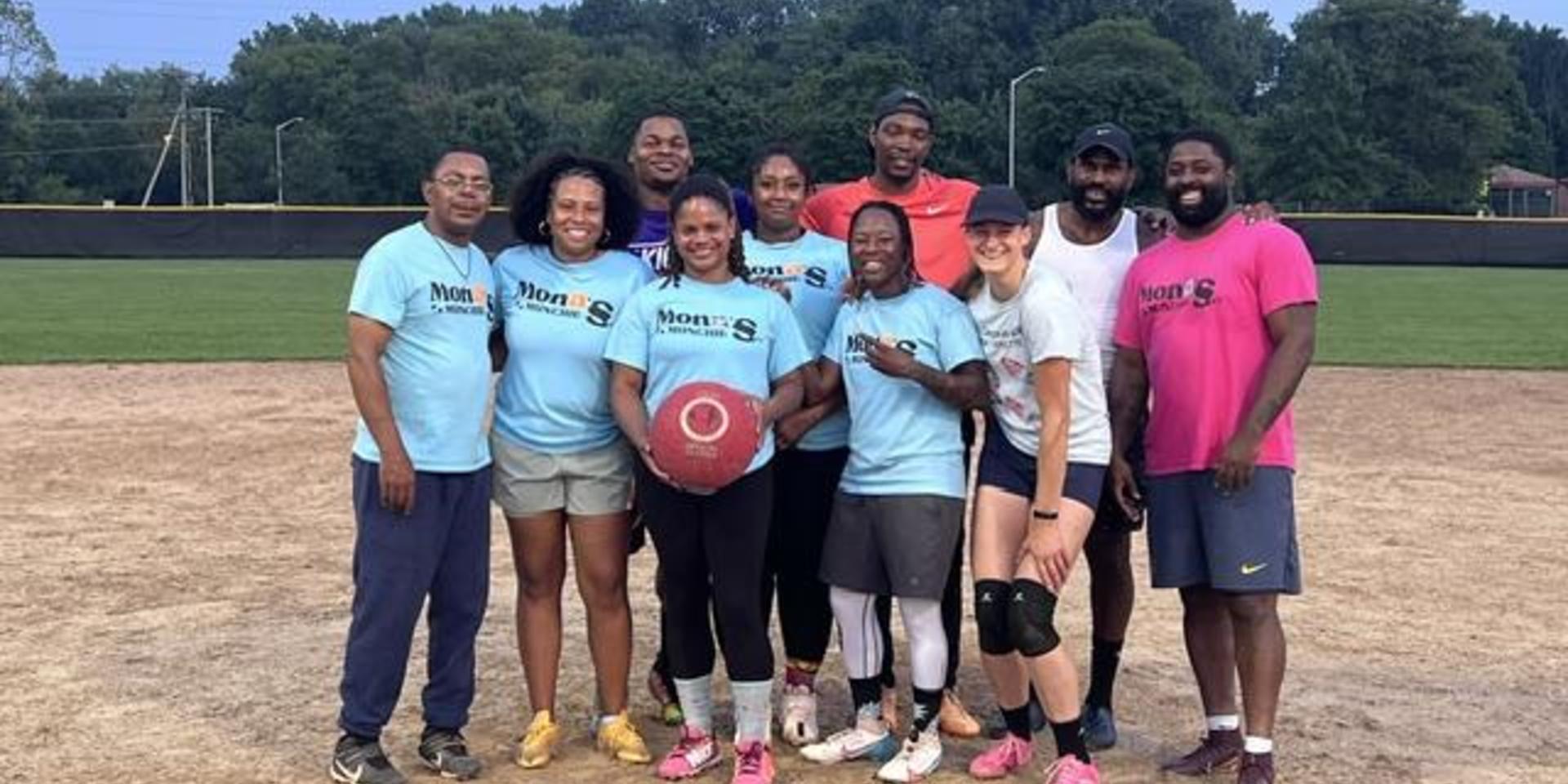 Team of adults gathered on a baseball field, ready for a game.