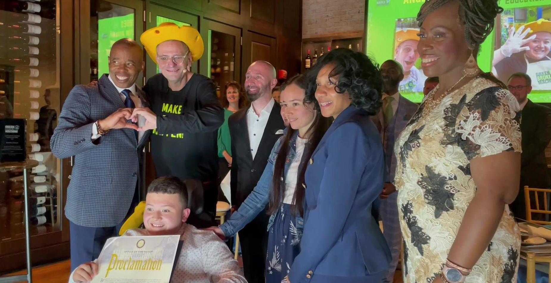 A group of staff and students celebrating an achievement, posing for a photo with a certificate.