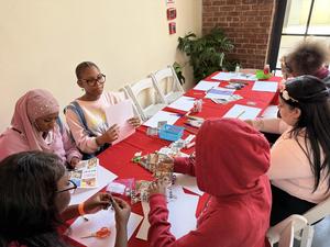 Girls crafting and working on projects at a table with art supplies.