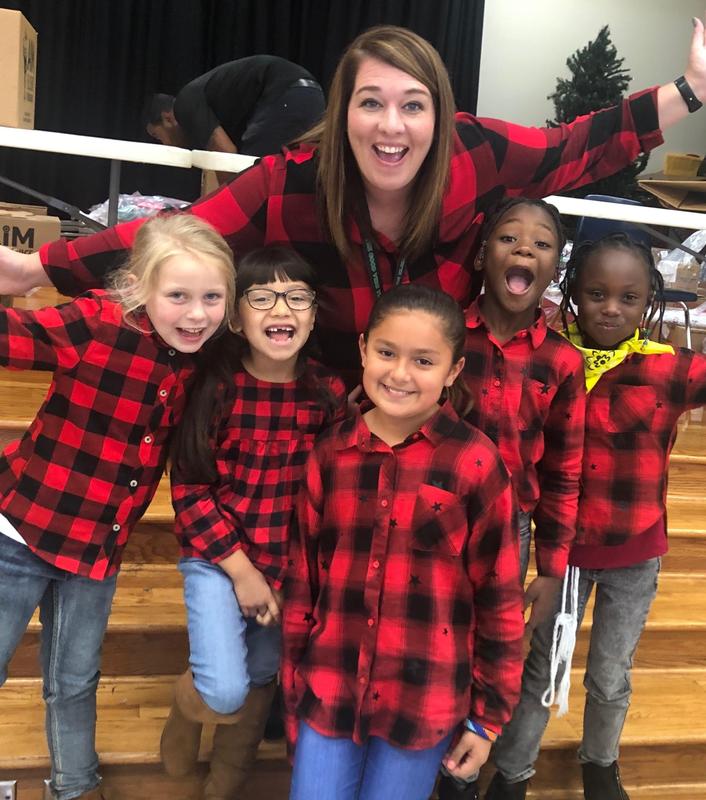 principal poses with 5 students in matching shirts