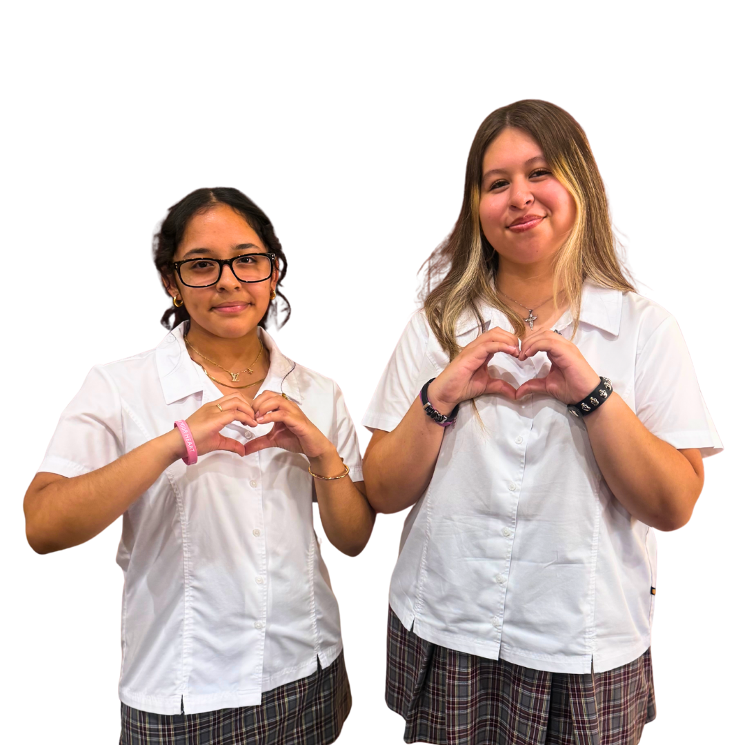 Two students hold their hands up to make hearts