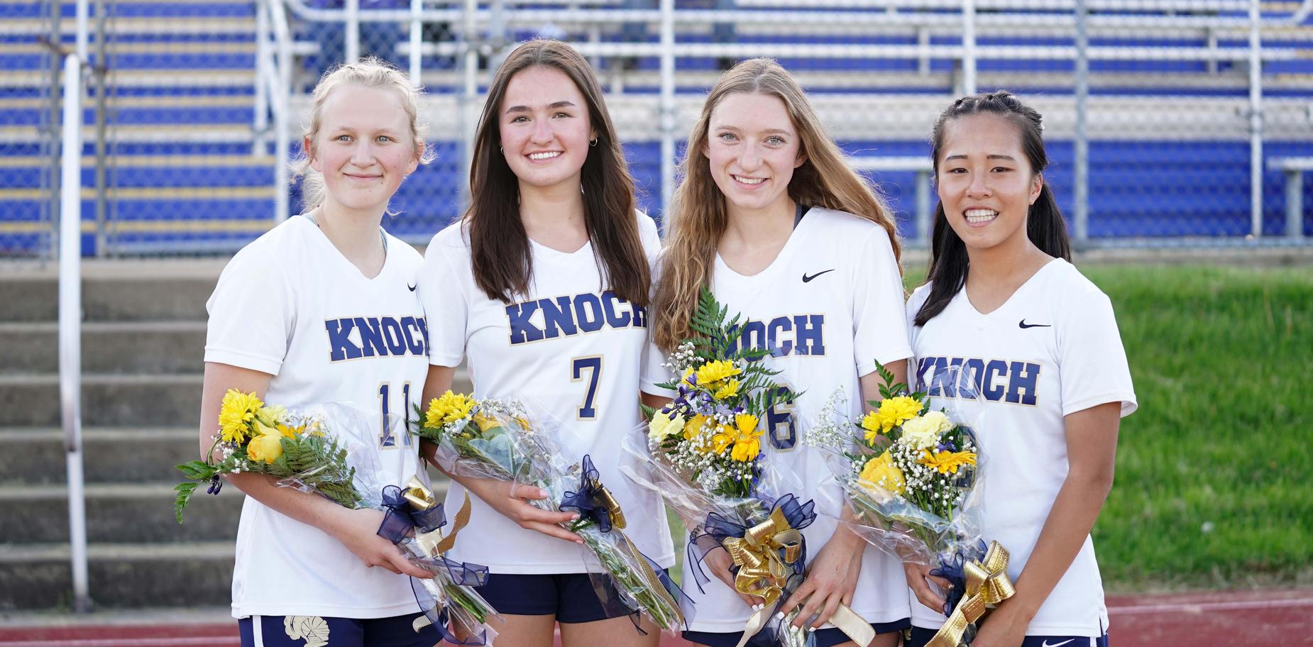 4 senior players holding flowers