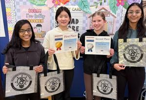 Four girls holding tote bags