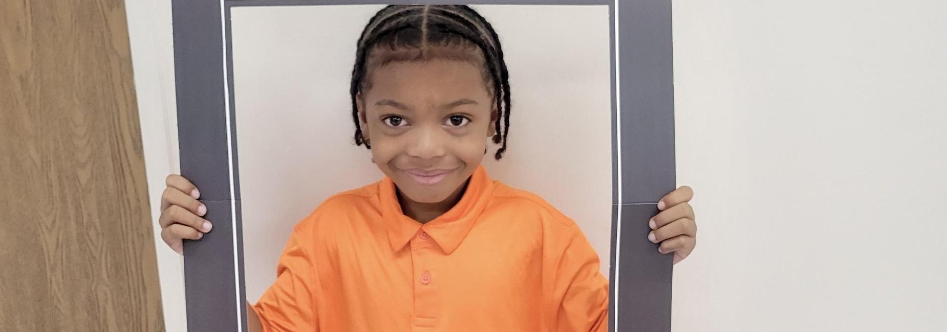 Young African American male student says "Hello" on the first day of school