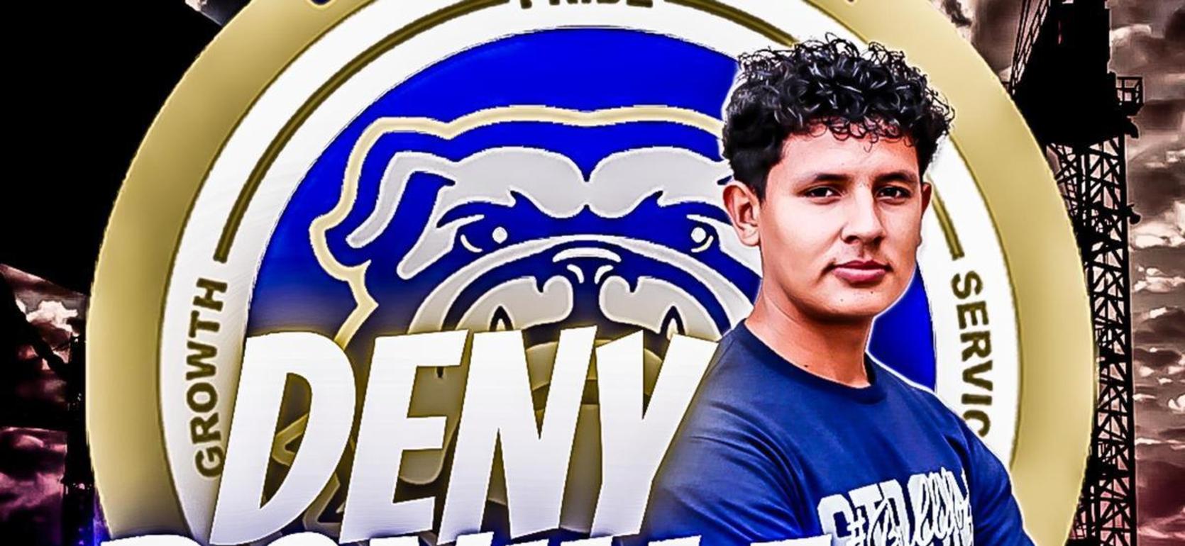 A young man poses with a crest featuring a bulldog in the background.
