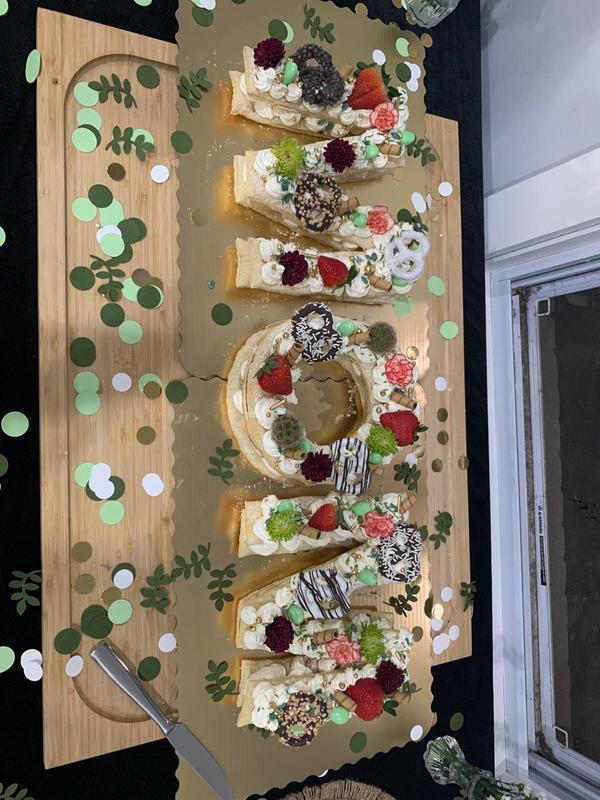 A cookie cake shaped into the word "MOM"