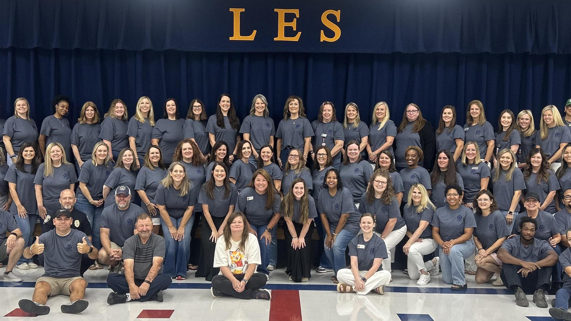 Group of staff members posing together in a school setting.