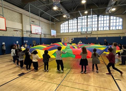 Students playing parachute game in gym class.