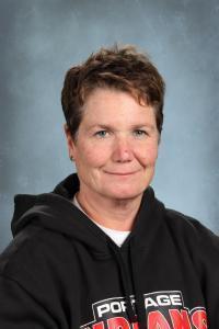 Middle-aged woman wearing a black hoodie, looking at the camera with a slight smile.