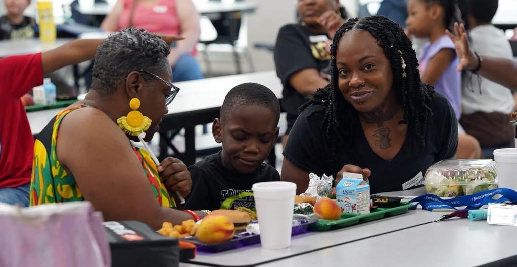 Student eating lunch with family for Grandparent's Lunch