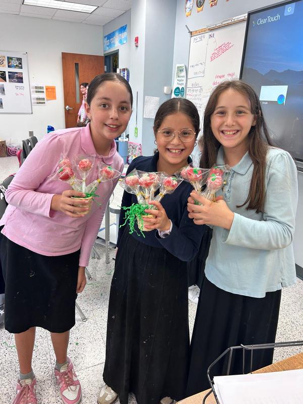 Three 6th graders show off their completed cake pops