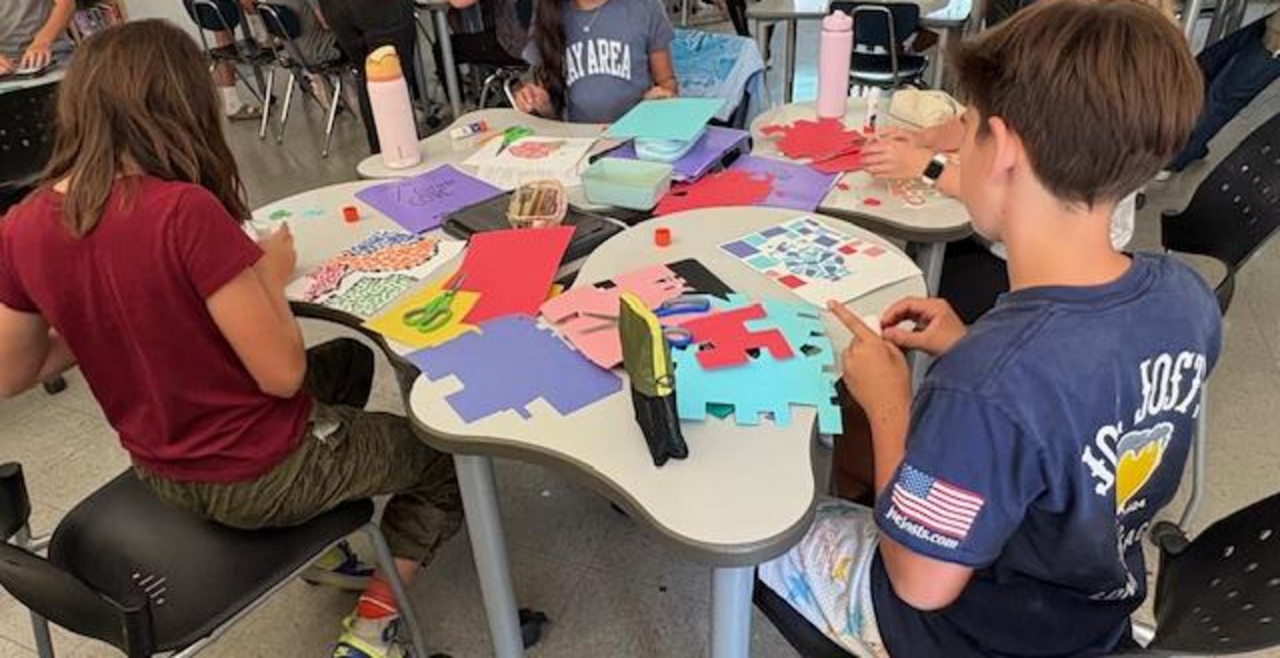 Students working in a group on mosaic art projects.