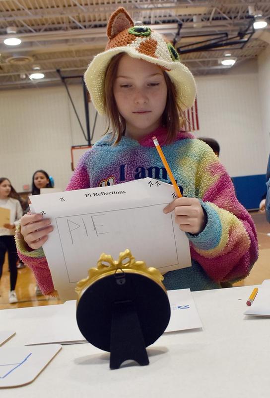 a girl holding a piece of paper with the word PIE