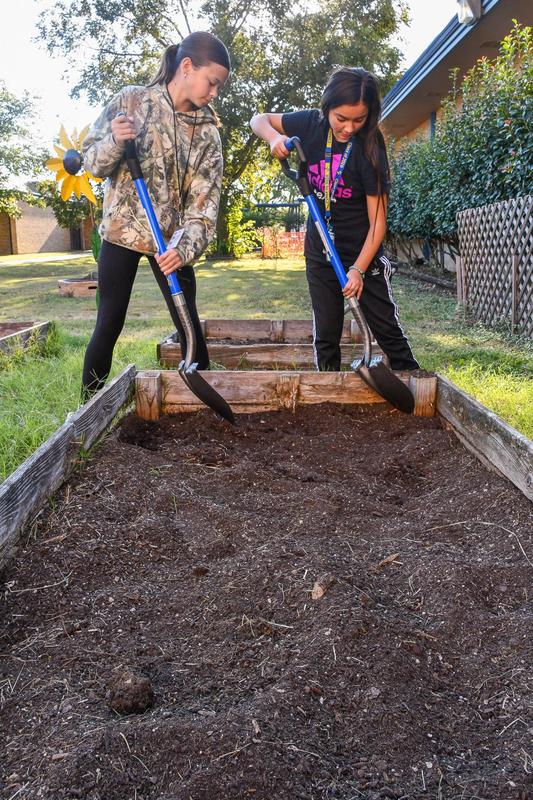2 students shoveling dirt