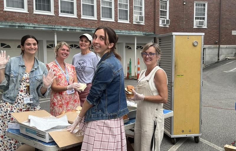 Several of our teachers help to wrap burgers and hot dogs for the BBQ