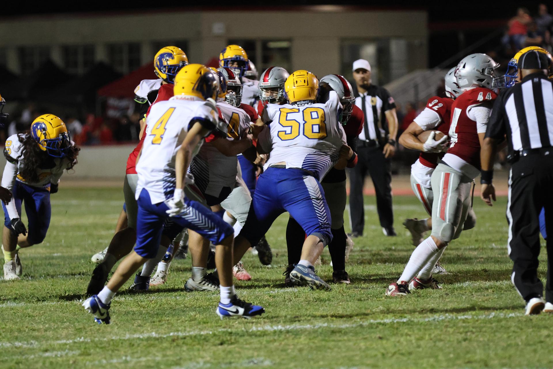 Varsity football players in action against Parlier 107