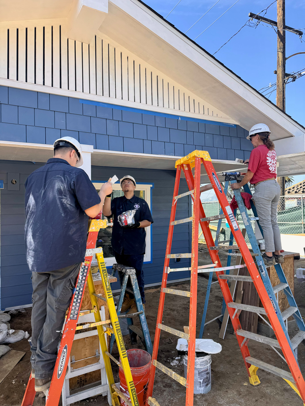 BPACE students paint house roof trimming.