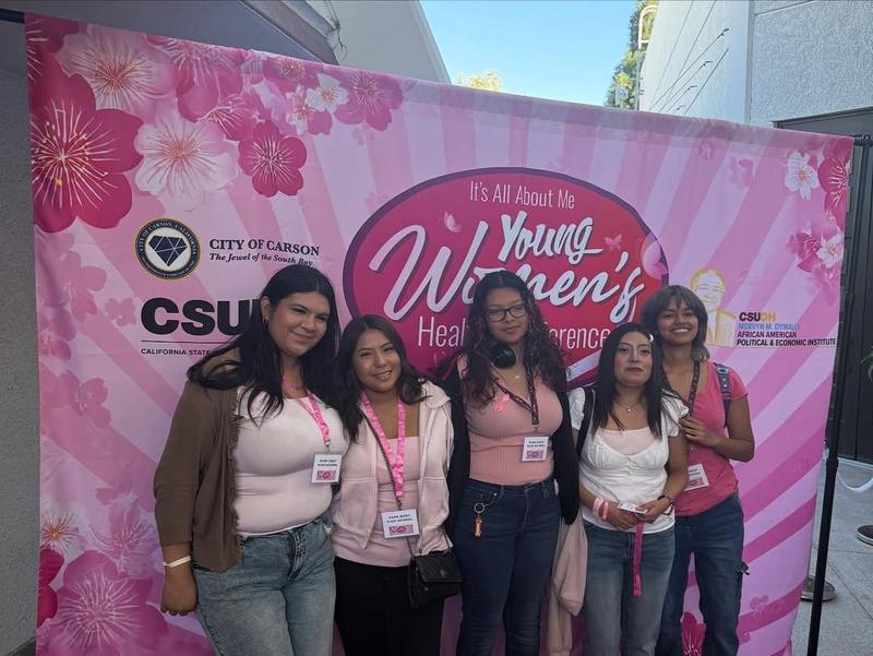 students pose in the photo step and repeat of the event wings