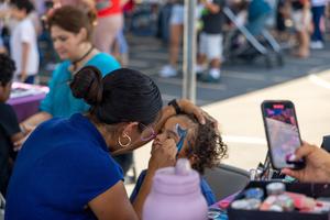 Child gets face painted at 70 Happiest Hours