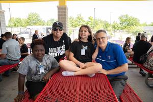 Students and mentors smile after eating lunch