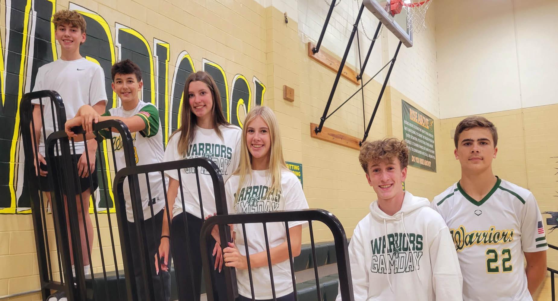 Group of students standing on bleachers in school spirit attire.