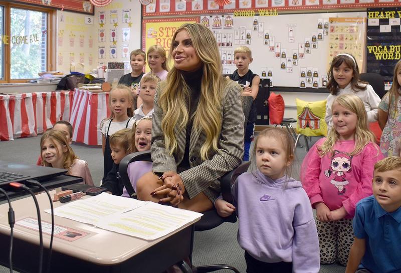 A teacher and young students all looking in one direction.