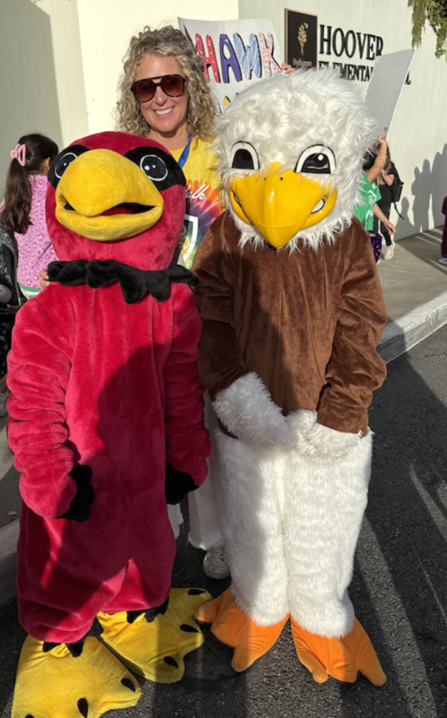 Two school mascot hawks and Principal Kraska