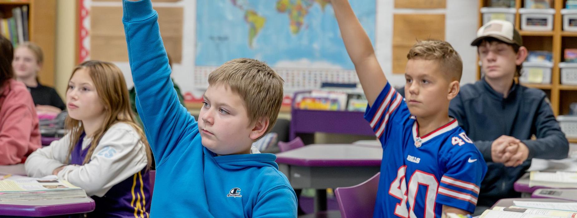 middle school students raising hands