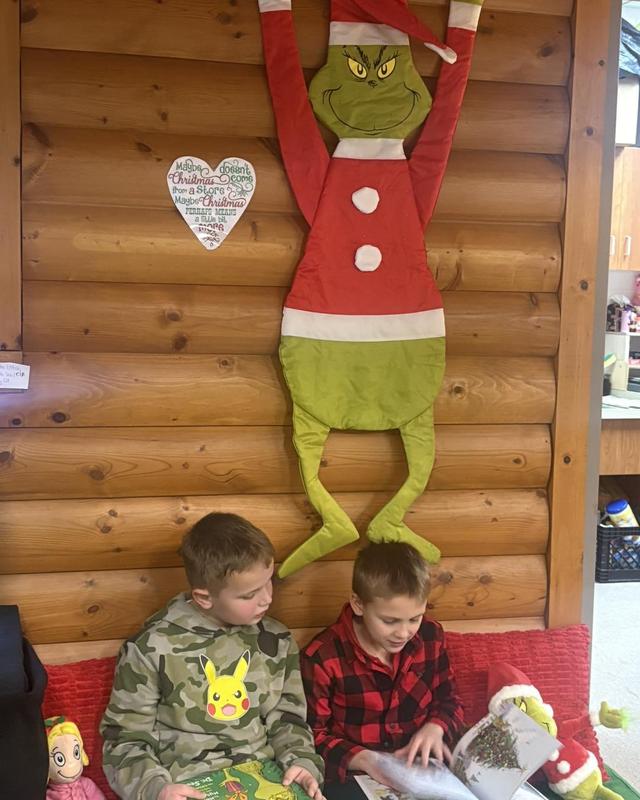 two boys reading under a grinch sign