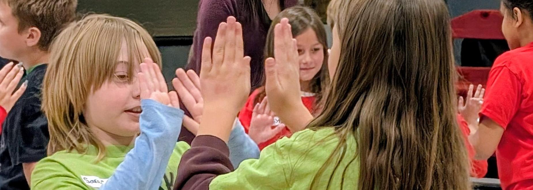 Students high five each other during activity to connect