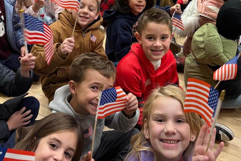 Level Green students waved American flags at their schoolwide assembly