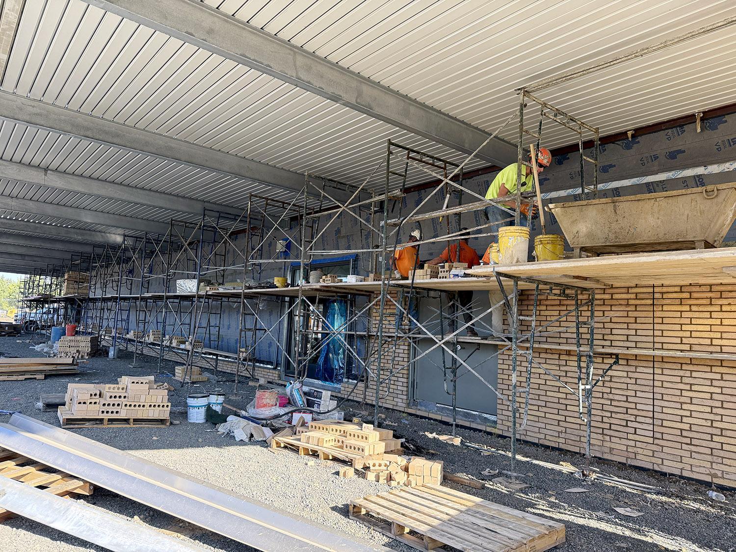 bricklaying along wall under covered play canopy