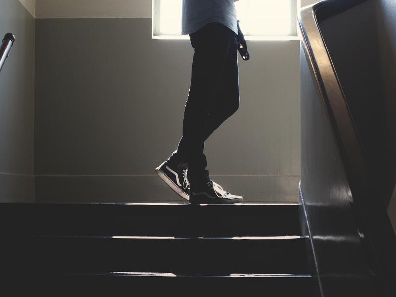 Person walking down a set of stairs in silhouette.