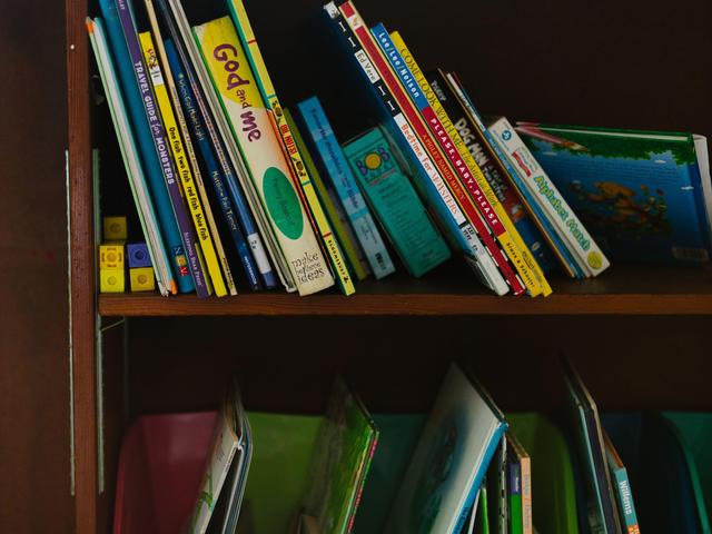 A bookshelf filled with colorful children's books and educational materials.