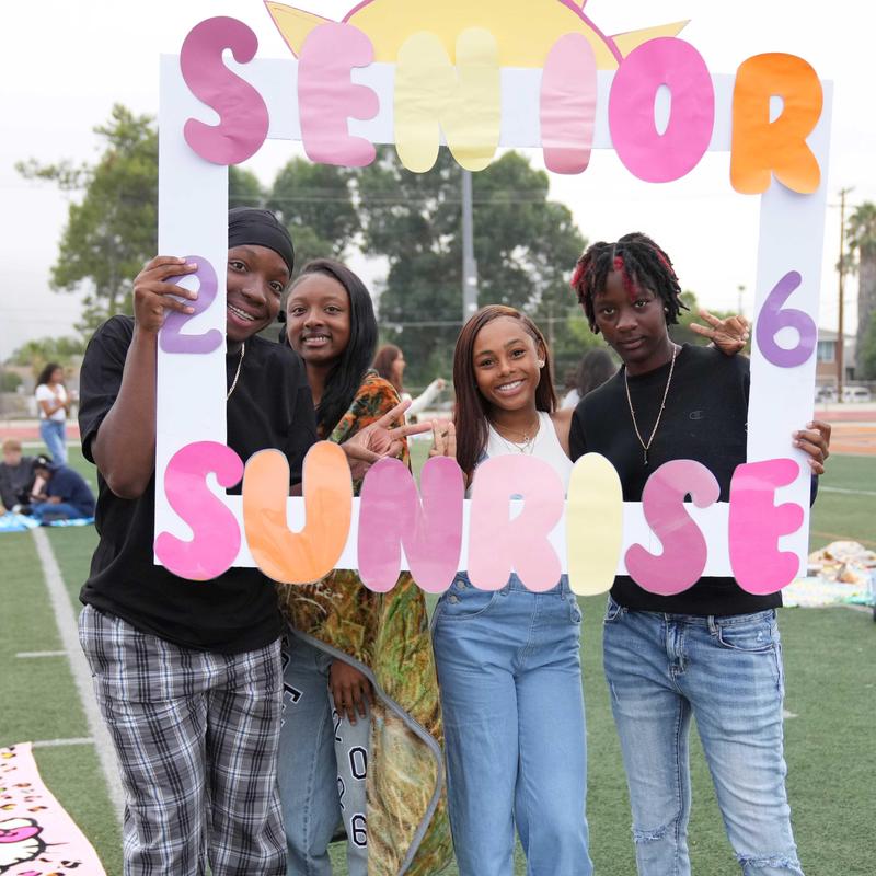 four students holding Senior Sunrise poster frame