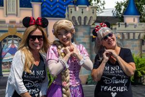 Teachers pose with Rapunzel at 70 Happiest Hours.