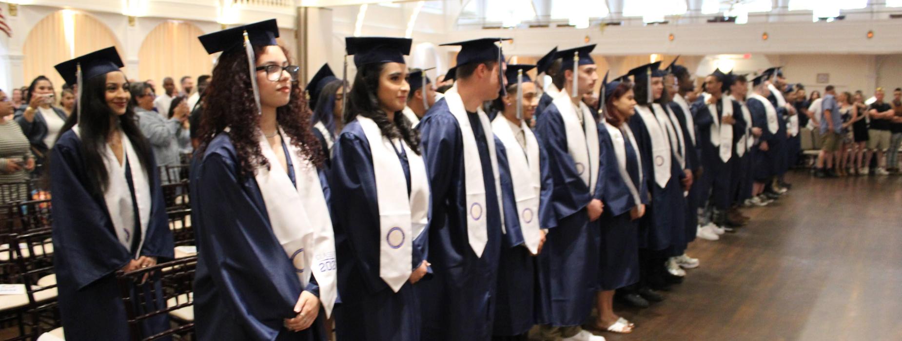 AES students stand for the beginning of the graduation ceremony.