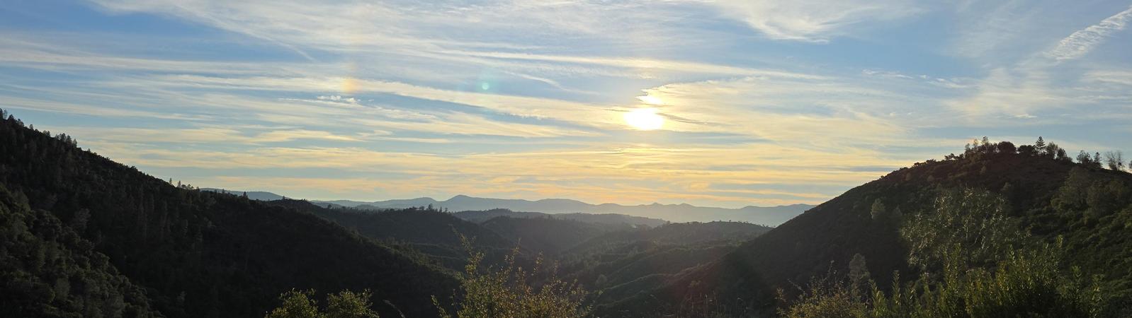 sun and clouds over the hills