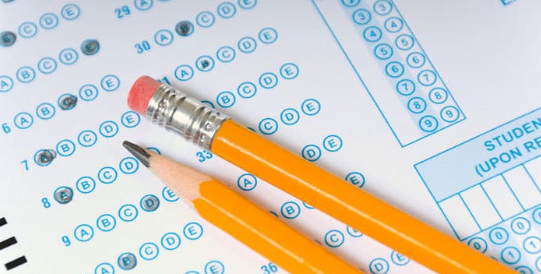 A blue bubble sheet test with two yellow pencils resting on it