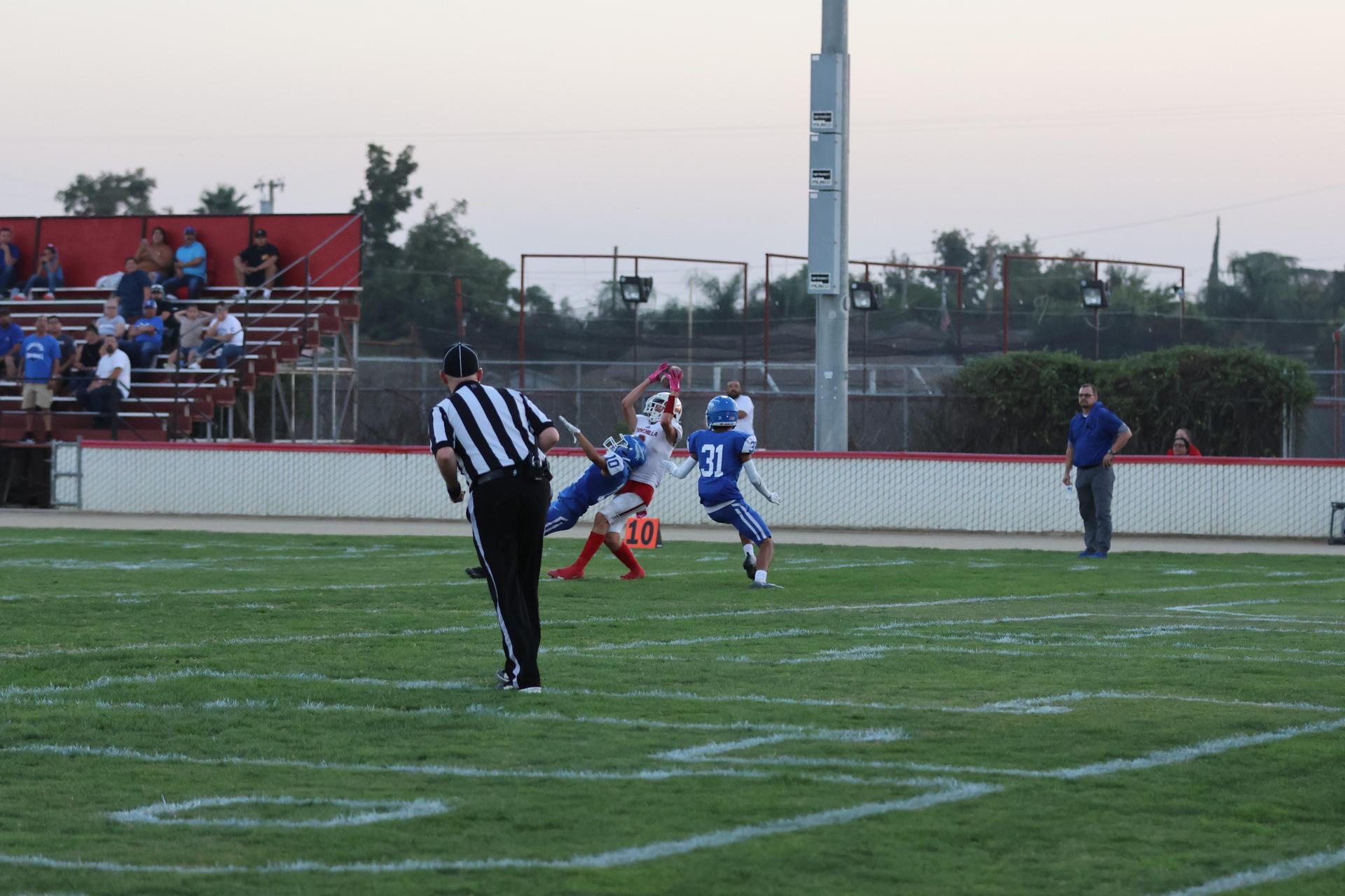 Junior Varsity football players in action against Caruthers