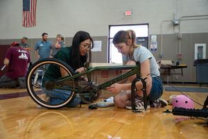 A student and volunteer work together to build a bicycle