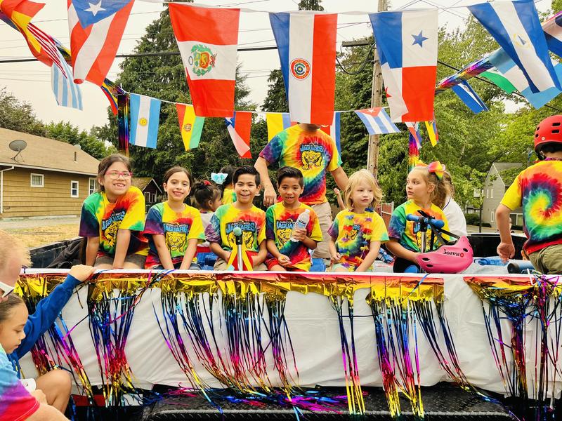 Arco Iris students smile on a parade float.