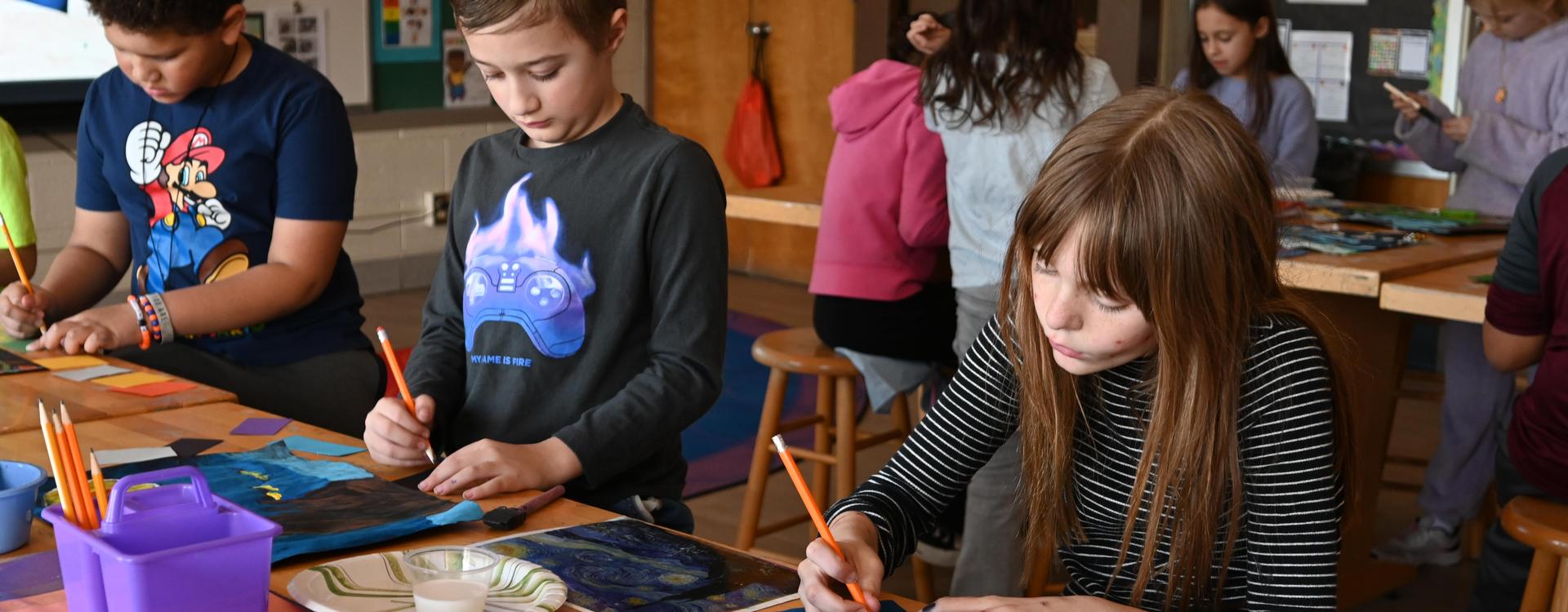 Children create art with paint in a classroom setting.