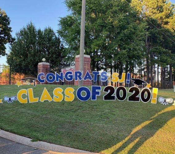Blue and gold lettering on grassy hill