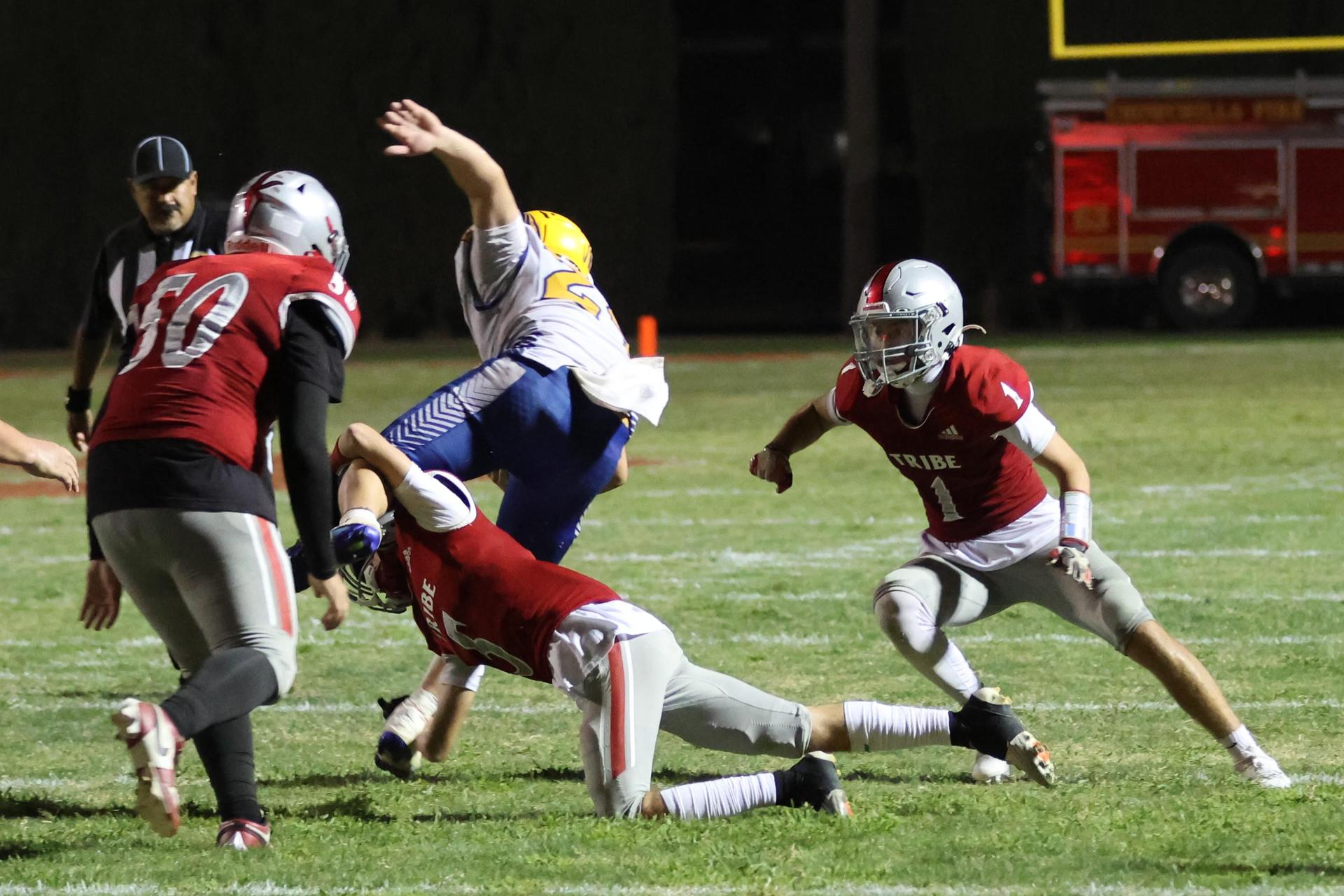 Varsity football players in action against Parlier 79