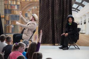 Two actors recreate a scene depicting Rosa Parks on the bus.