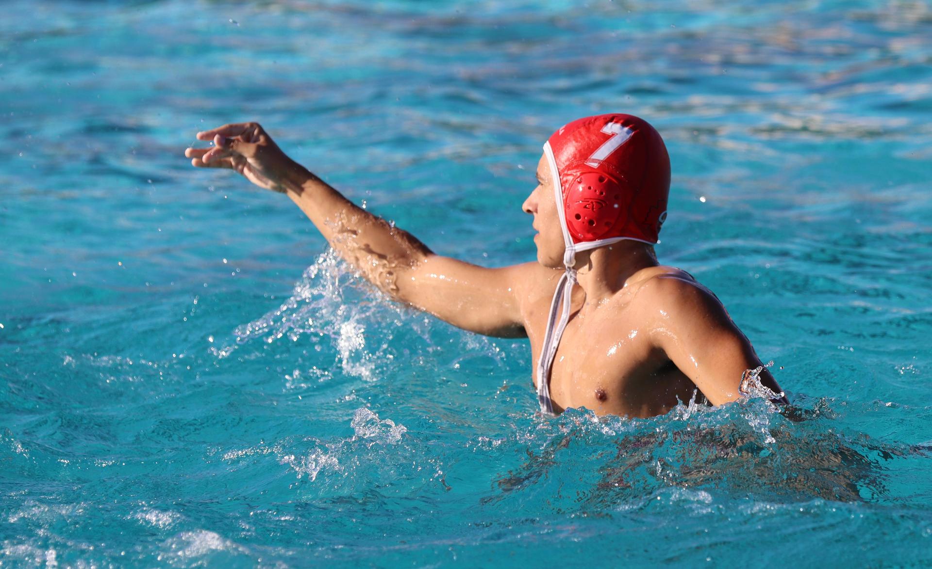 boys water polo players in action against hoover