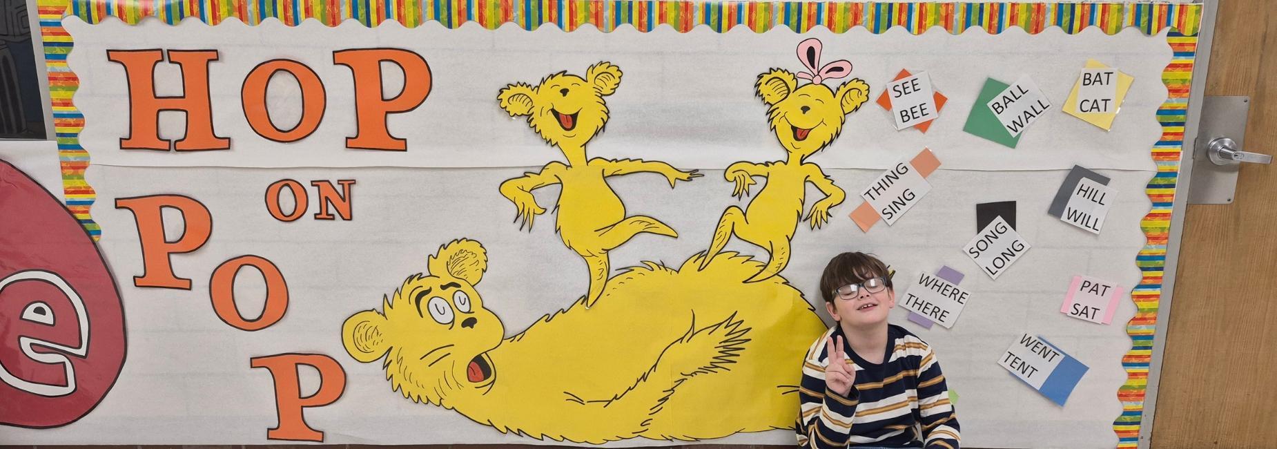Colorful children's banner featuring characters with the text 'HOP ON POP'.