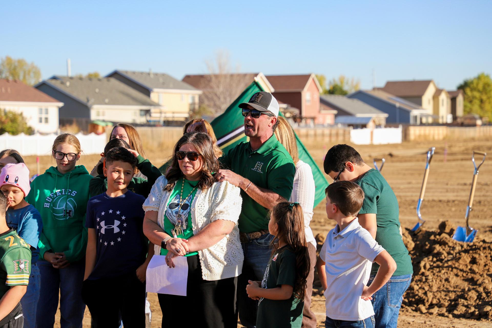Mrs. M standing with students and staff at the ground breaking for the k-8 school